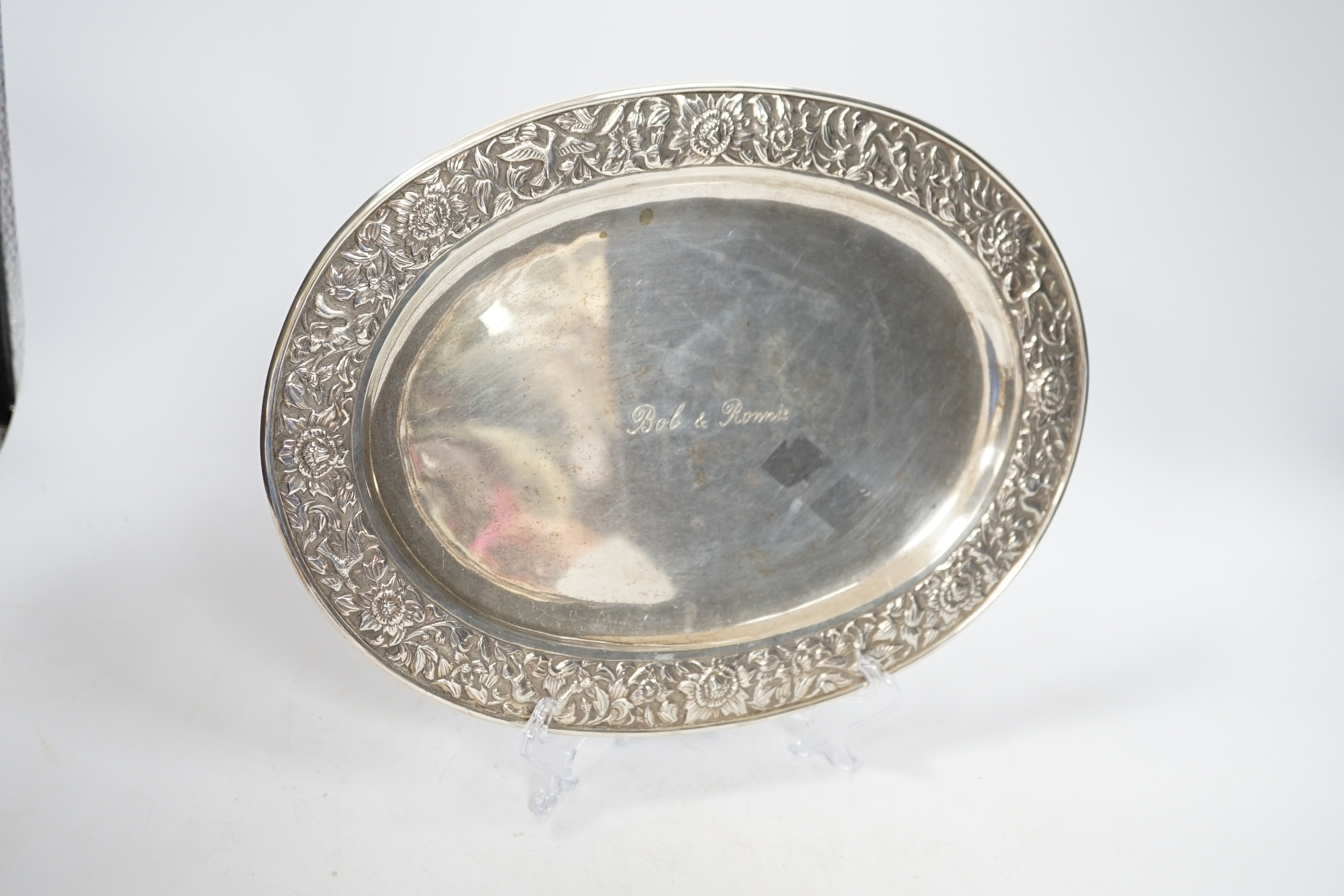 A Thai white metal oval salver, the border decorated with flowers, birds and squirrels, stamped sterling, 31cm
